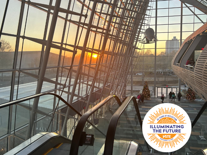 An image of the convention center looking from inside to outside at the setting sun.